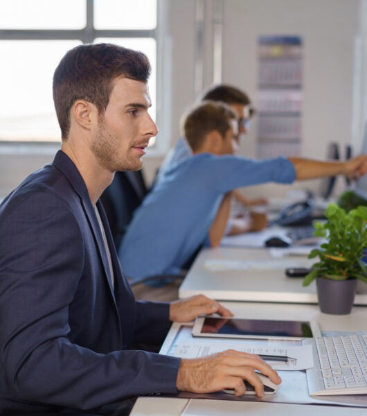 Young,Businessman,Synchronising,Data,Between,His,Tablet,Pc,And,Desktop